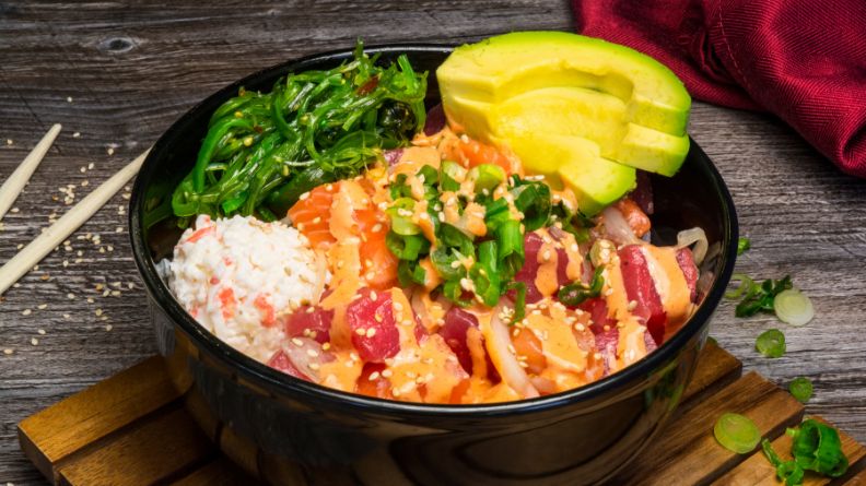 Pokebowl met rijst, tonijn en zalm sashimi en japanse zeewier (wakame)